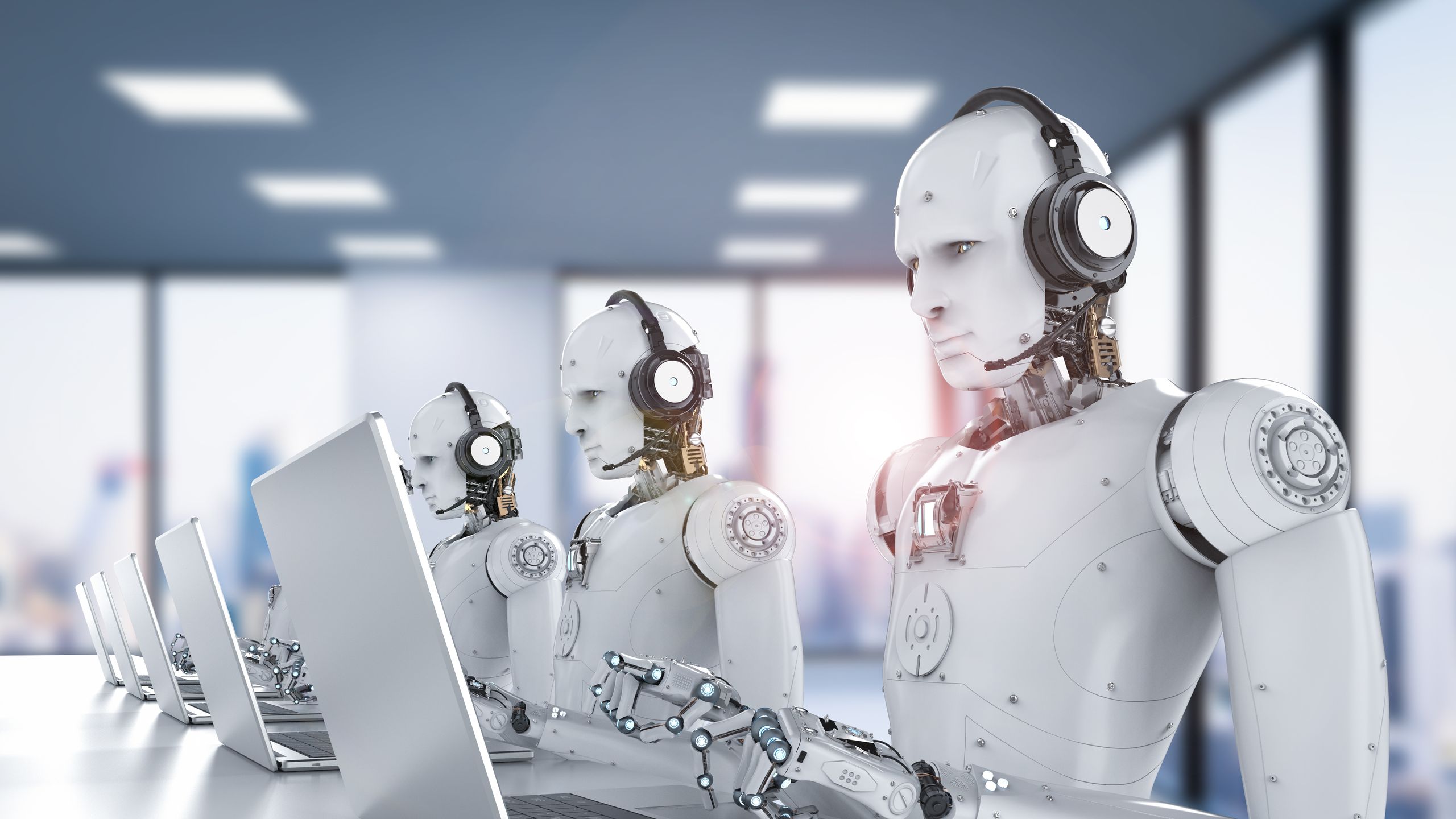 Robots trabajando con computadoras en una oficina moderna