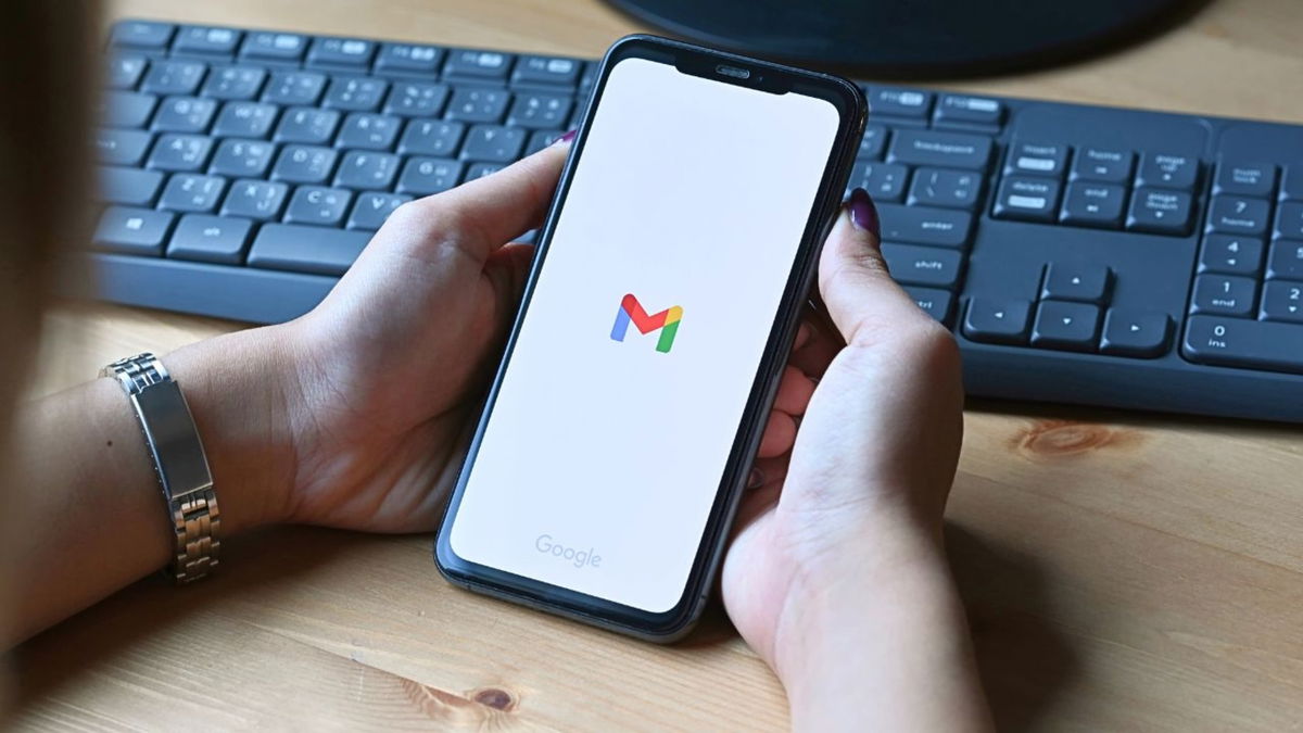 Persona mostrando un smartphone con el logo de Gmail
