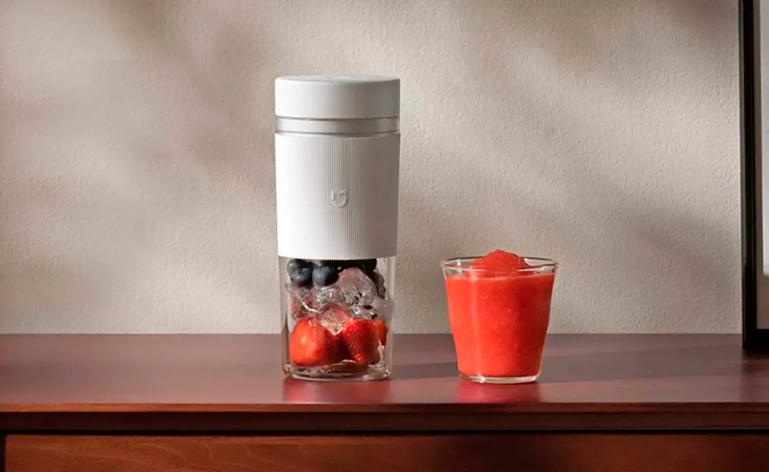 Xiaomi Portable Blender con frutas frescas y un vaso de zumo