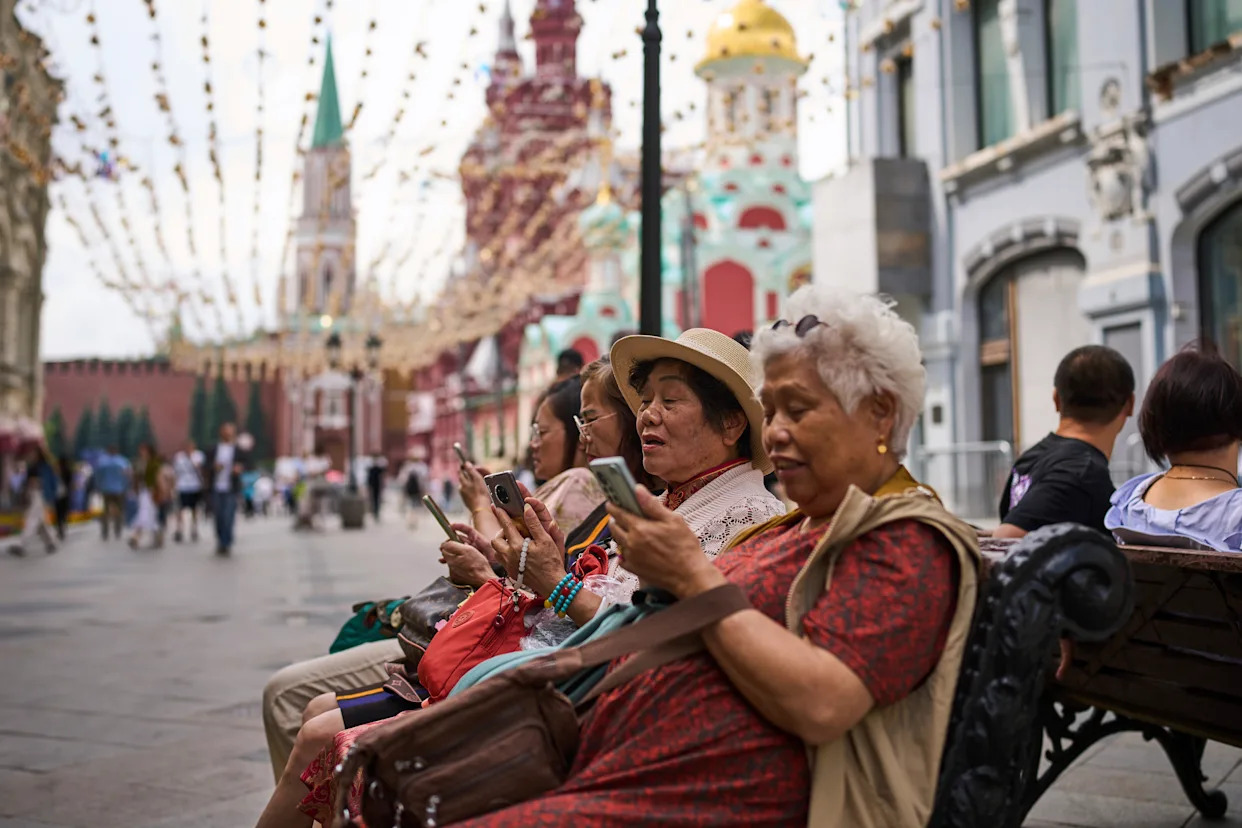 Mujeres usando sus teléfonos en la Plaza Roja de Moscú