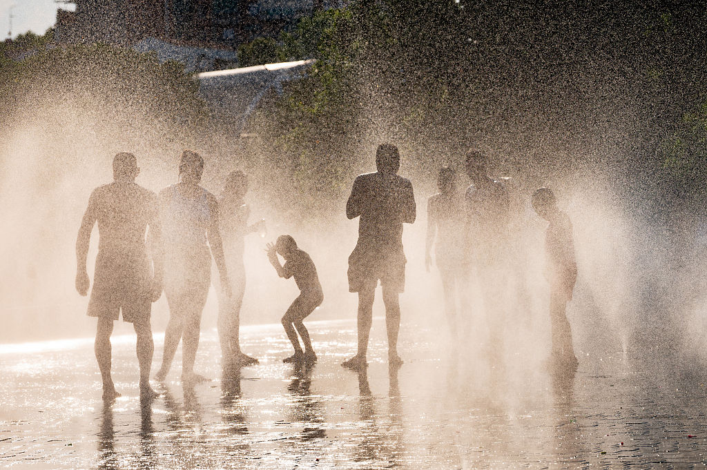 Personas refrescándose en una fuente durante una ola de calor en Europa