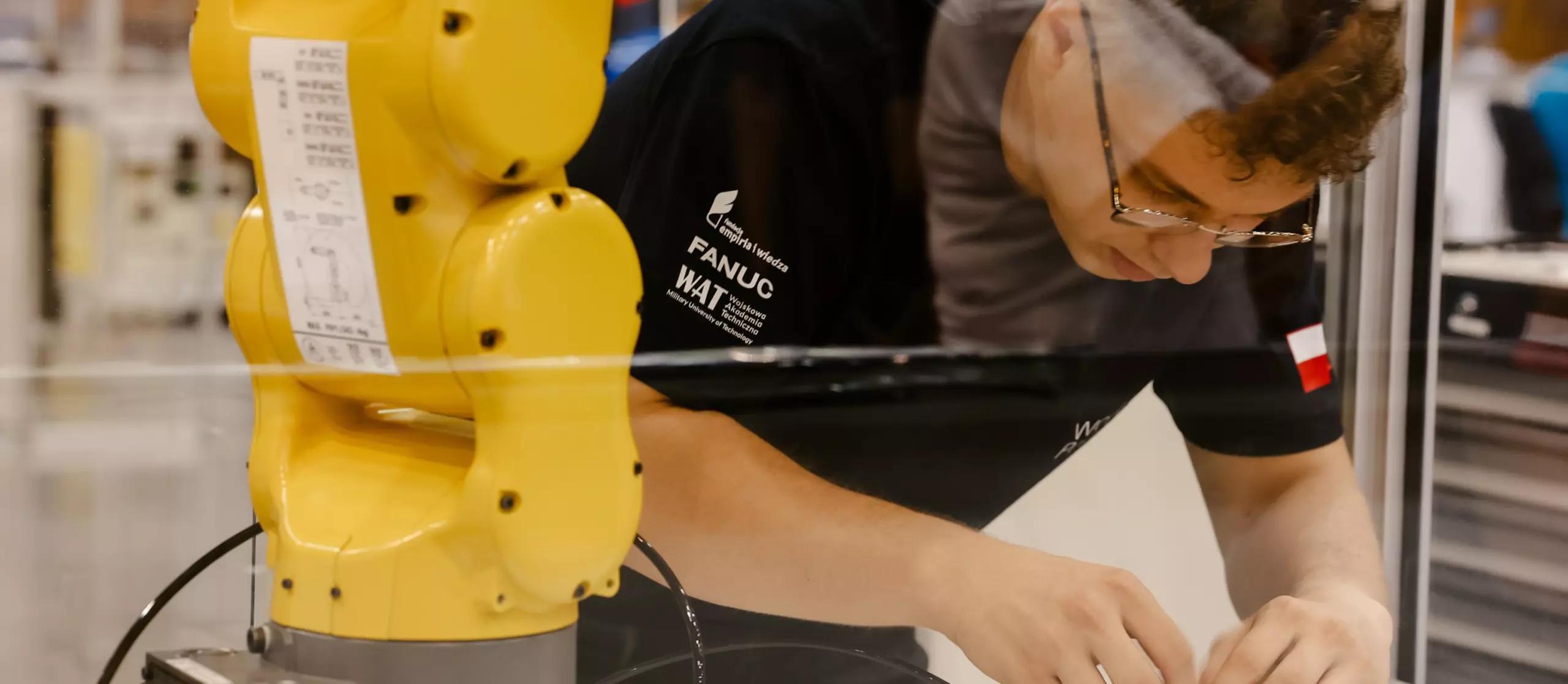 Competidor operando un robot industrial FANUC en una competición