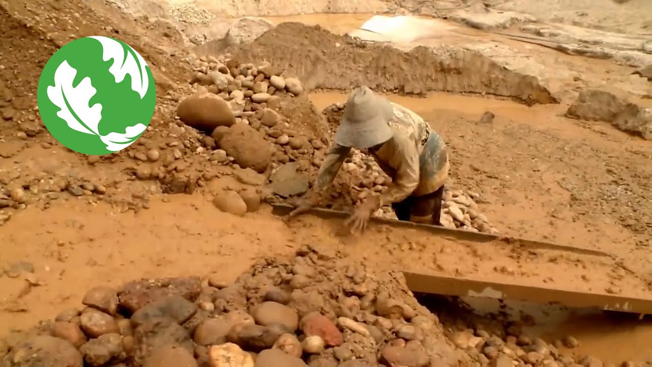 Minero trabajando en zona arenosa con maquinaria
