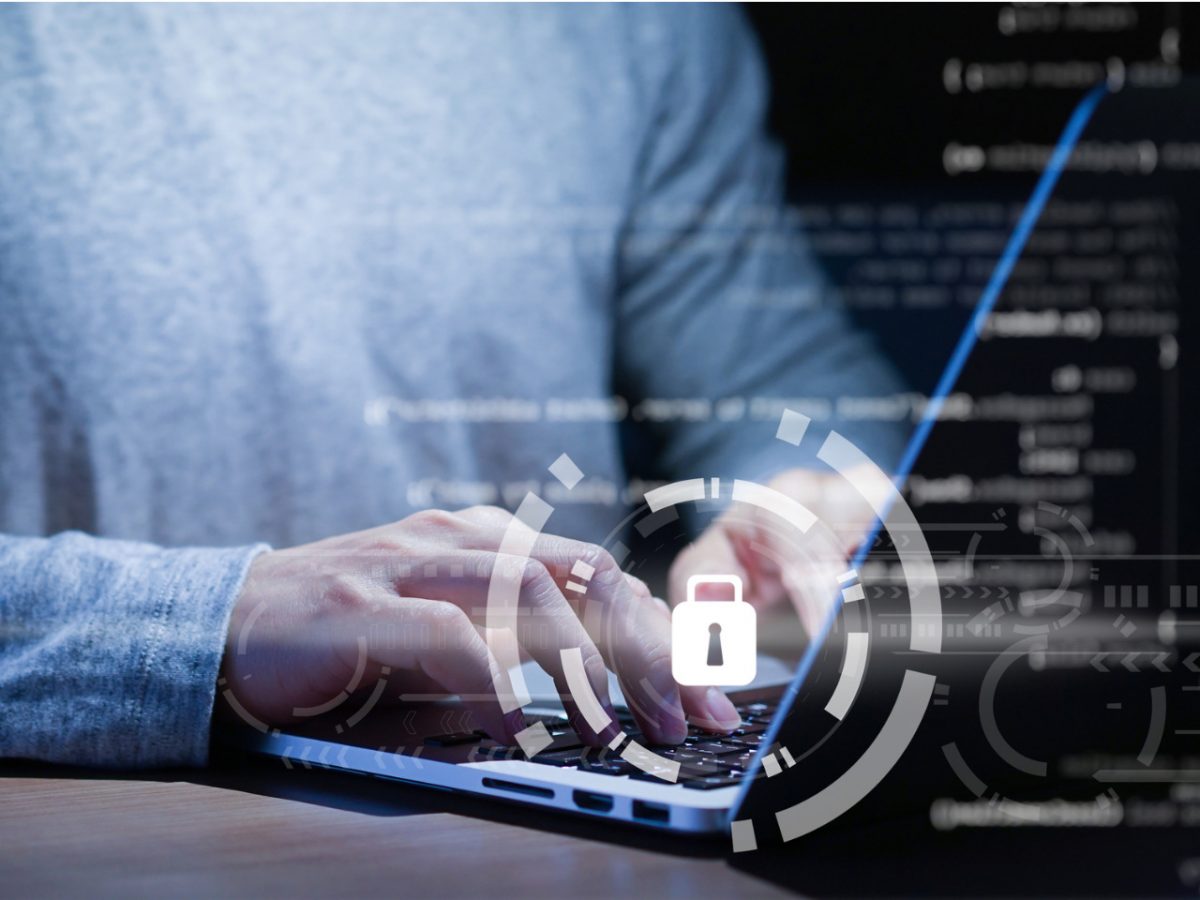 Persona trabajando en seguridad informática con iconos de protección