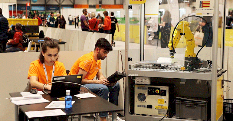 Representantes españoles operando un robot industrial
