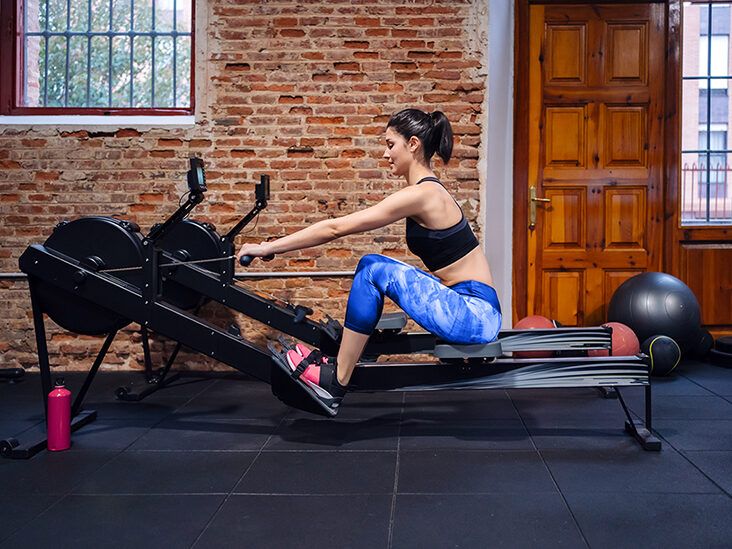 Woman using rowing machine in gym
