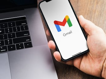 Persona sosteniendo teléfono con logo de Gmail